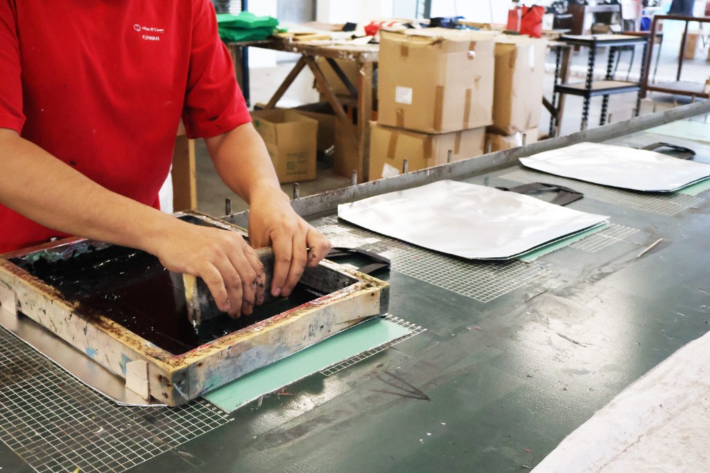 Screen printing custom tote bags in production